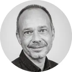 Dan Drury. Dan is a white man with very short dark hair and stubble. He is wearing a dark collared shirt